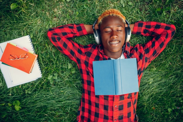 Étudiant noir reposant sur l'herbe, vue du dessus