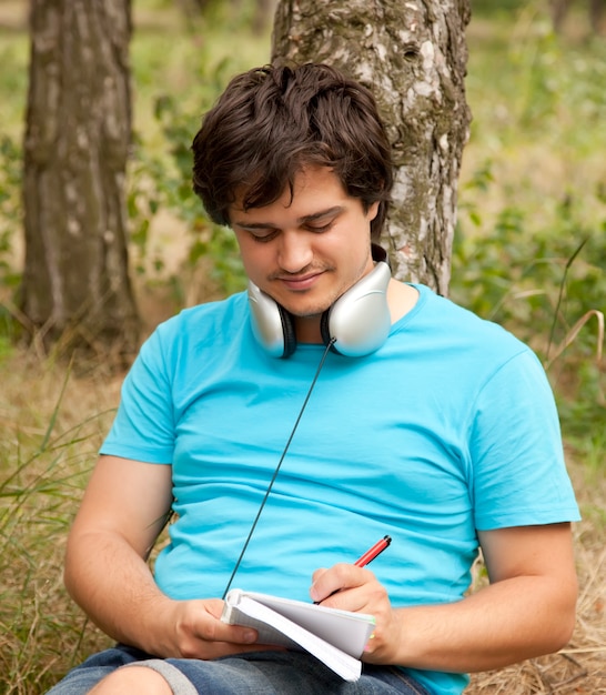 Étudiant avec ordinateur portable et écouteurs.