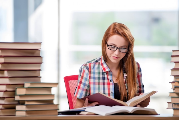 Étudiant avec des piles de livres préparant des examens