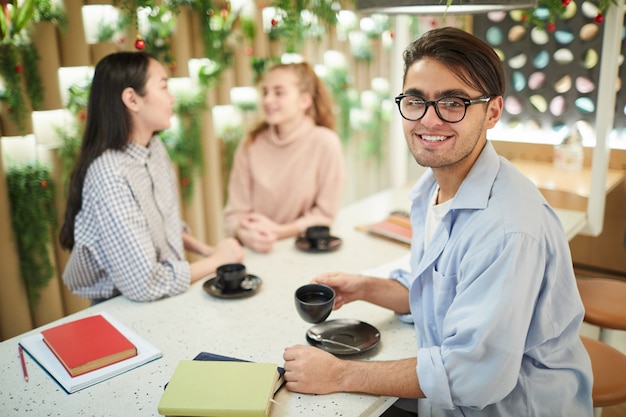 Étudiant de race mixte souriant au café