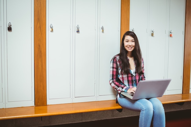 Étudiant souriant assis à l&#39;ordinateur