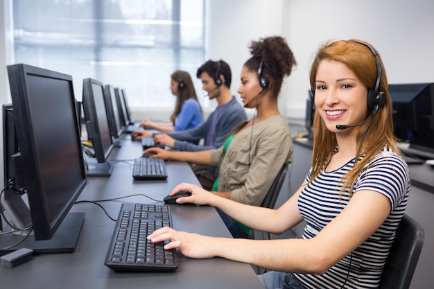 Étudiant souriant à la caméra dans un cours d&#39;informatique