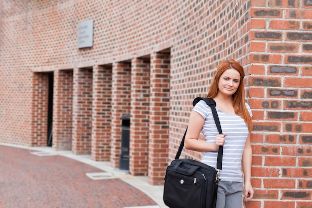 Étudiant souriant posant avec un sac