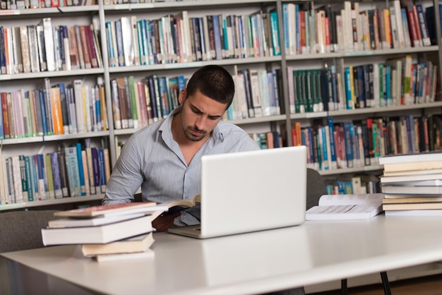 Étudiant stressé du lycée assis au bureau de la bibliothèque faible profondeur de champ