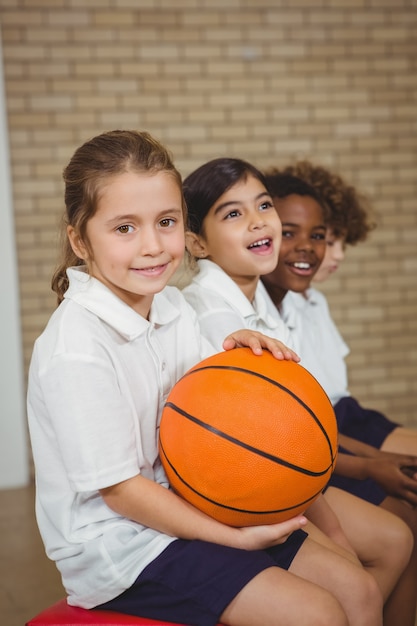 Étudiant tenant le basket-ball avec d&#39;autres joueurs