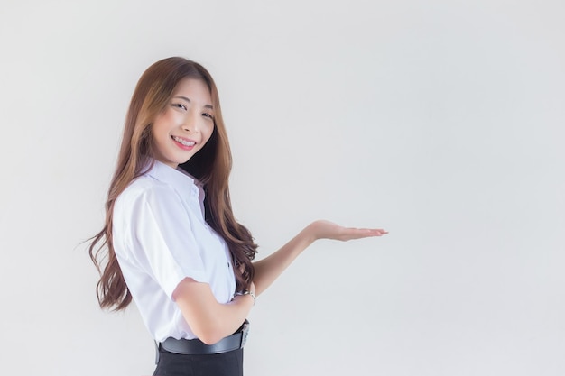 Étudiant thaïlandais en uniforme universitaire Asiatique belle fille debout pour présenter quelque chose en toute confiance