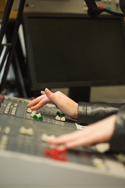 Étudiant travaillant sur les niveaux sonores de bureau de réglage dans le studio