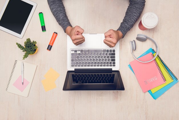 Étudiant travaillant avec un ordinateur portable sur le bureau. Vue de dessus