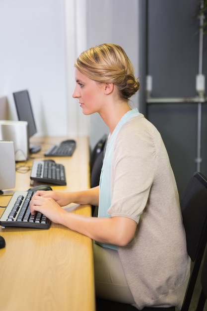 Étudiant travaillant sur ordinateur en salle de classe