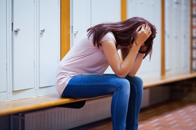 Étudiant triste assis sur un banc