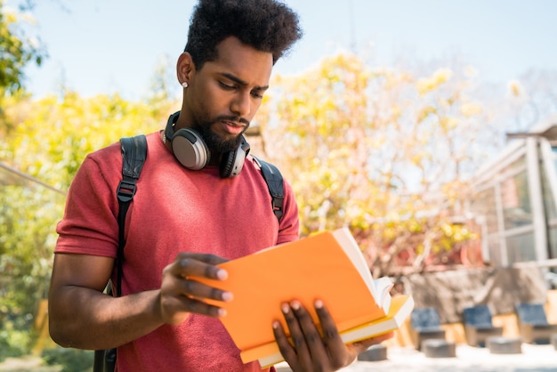 Étudiant universitaire afro étudiant et lisant son livre