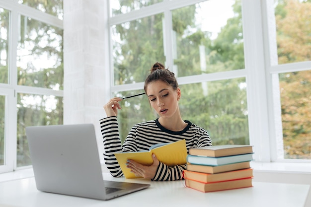 Étudiant universitaire faisant des travaux à domicile à domicile avec un ordinateur portable