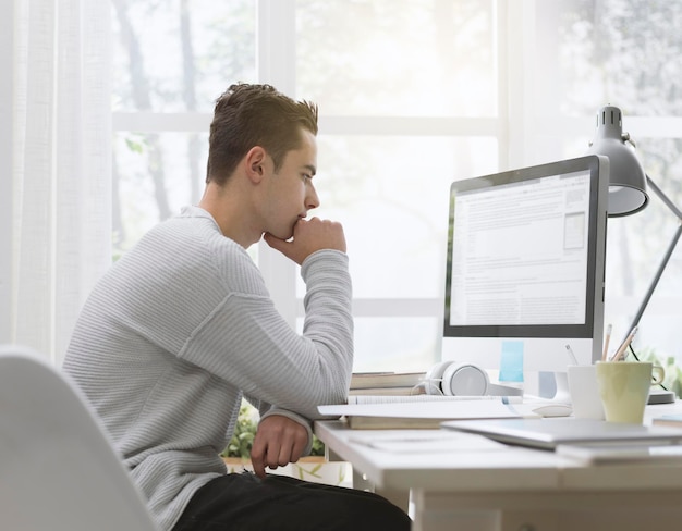 Étudiant universitaire utilisant un ordinateur à la maison