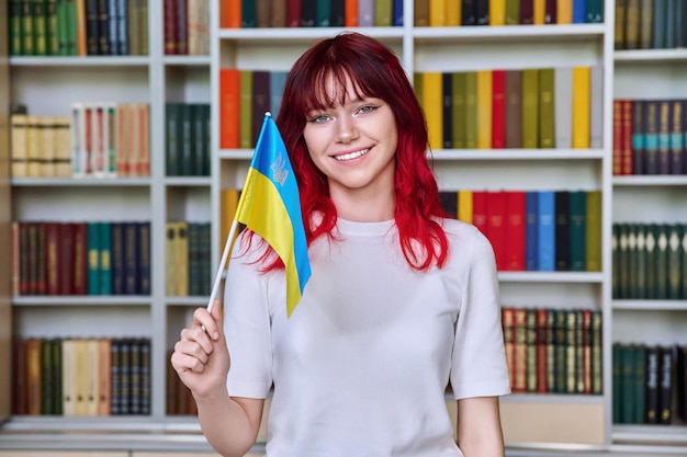 Étudiante adolescente avec le drapeau de l'ukraine dans la bibliothèque