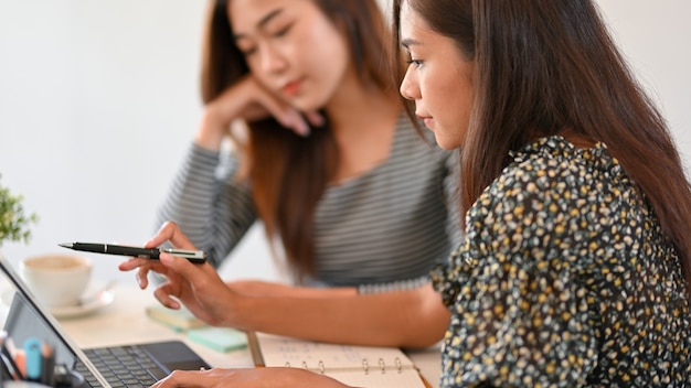 Étudiante à l'aide d'une tablette pour enseigner les devoirs de mathématiques à son camarade de classe