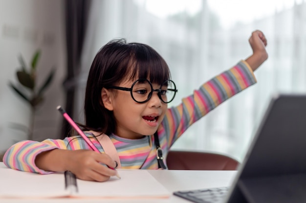 Étudiante asiatique en ligne apprenant en classe étudier en ligne avec l'enseignant Une fille heureuse apprend l'anglais en ligne avec une tablette à la maison Nouveau normalCovid19 coronavirusDistanciation sociale rester à la maison