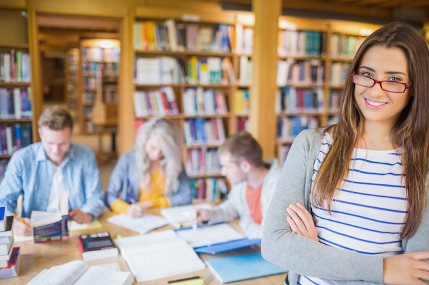 Étudiante avec d&#39;autres en arrière-plan à la bibliothèque