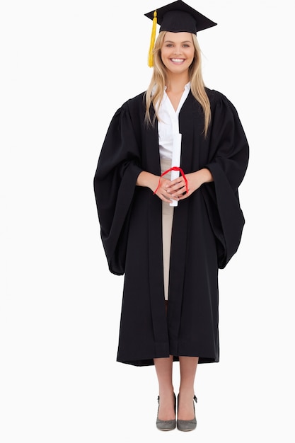 Étudiante blonde souriante en robe de diplômé