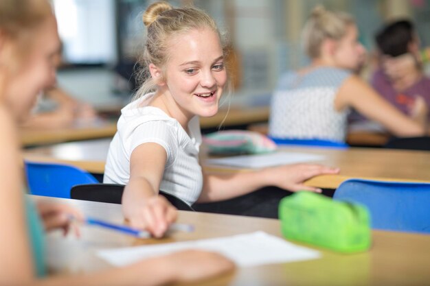 Étudiante empruntant un stylo pendant le cours magistral