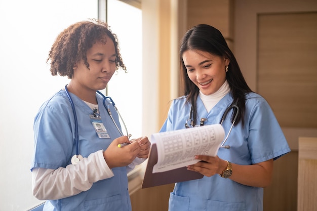 Étudiante en infirmière Groupe multiethnique d'étudiants en soins infirmiers heureux parlant du couloir de l'université médicale