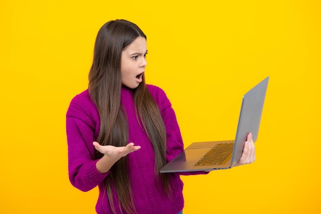 Étudiante jeune fille tenir ordinateur Élève drôle avec ordinateur portable isolé sur fond jaune Retour