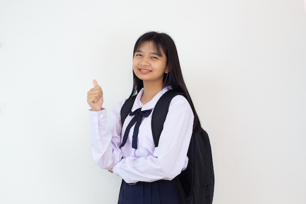 Étudiante jeune fille en uniforme et sac à dos sur fond blanc