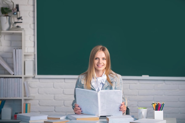 Étudiante lisant un livre sur le cours magistral en classe à l'école