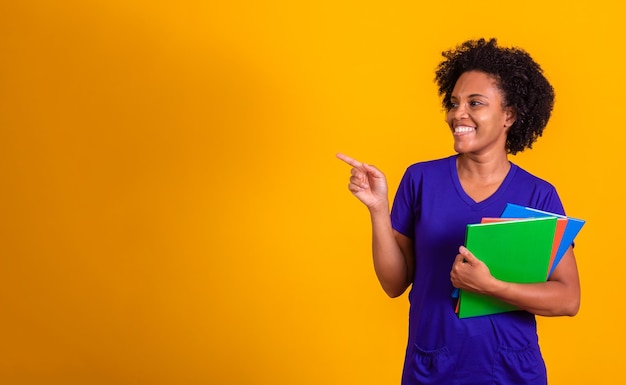 Étudiante mûre femme souriante regardant la caméra avec un espace pour le texte sur fond jaune