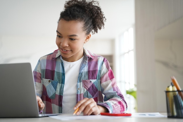 Étudiante de race mixte adolescente apprend en ligne sur un ordinateur portable Enseignement à distance elearning