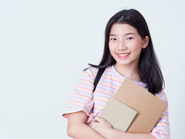 Étudiante tenant des livres avec des sacs à dos.