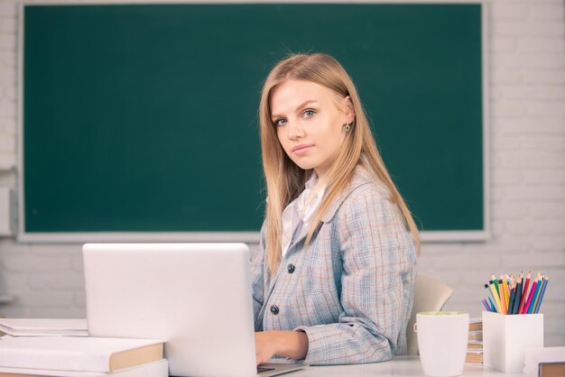 Étudiante travaillant sur un ordinateur portable dans une salle de classe se préparant à un examen Webinaire elearning à l'école enseignement à distance