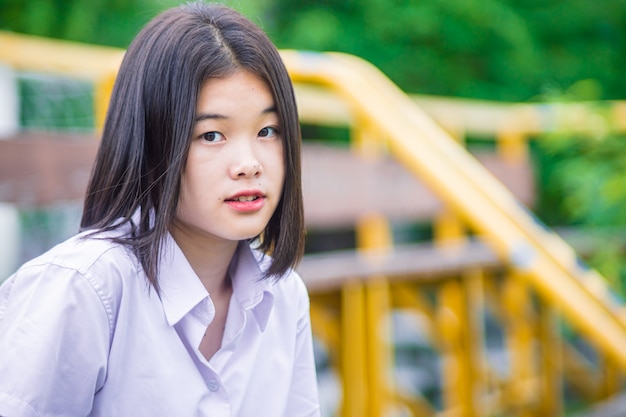 Étudiante universitaire asiatique, adolescente innocente, regard naïf avec fond