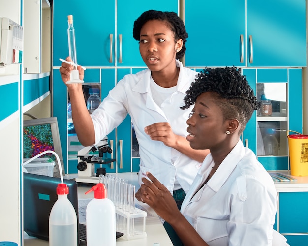 Étudiantes africaines en médecine, jeunes diplômés en recherche, laboratoire de tests médicaux effectuant divers tests sur des échantillons. Biopsie d'analyse microscopique, test d'acide nucléique pcr pour le coronavirus.