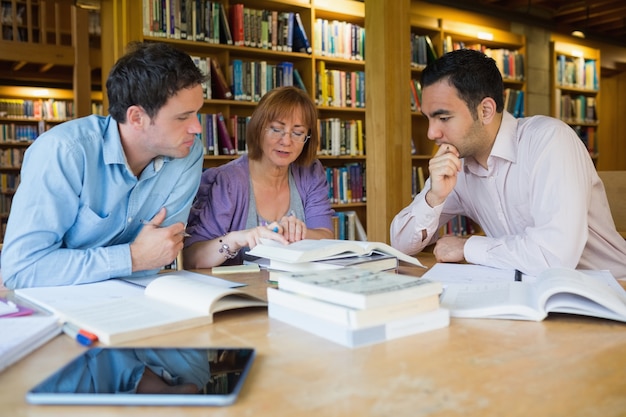 Étudiants adultes qui étudient ensemble dans la bibliothèque