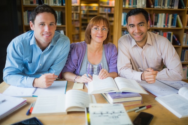 Étudiants adultes qui étudient ensemble dans la bibliothèque