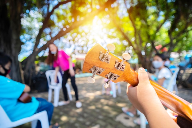 Étudiants asiatiques étudiant la musique Instruments de musique comme ukulélé apprenant en dehors de la salle de classe