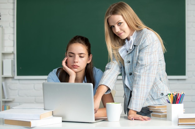 Étudiants filles amis en classe à l'école collège ou université deux étudiants faisant leurs devoirs toge