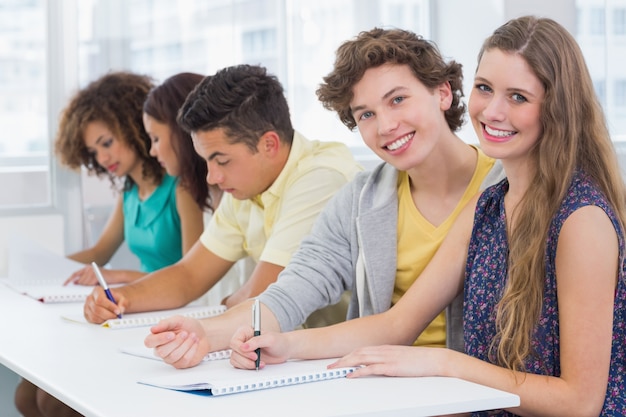 Étudiants de mode prenant des notes en classe