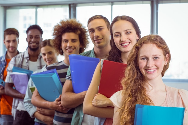 Étudiants de mode souriant à la caméra ensemble