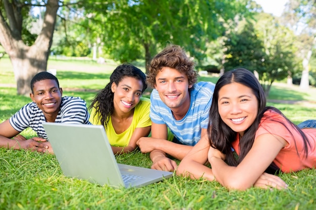 Étudiants avec ordinateur portable allongé sur le campus