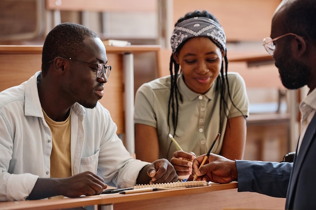 Étudiants parlant au professeur lors d'une conférence