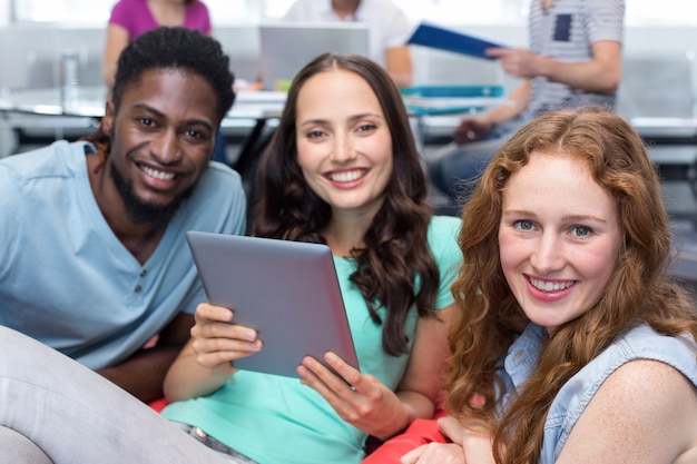 Étudiants souriants à l&#39;aide de tablette numérique