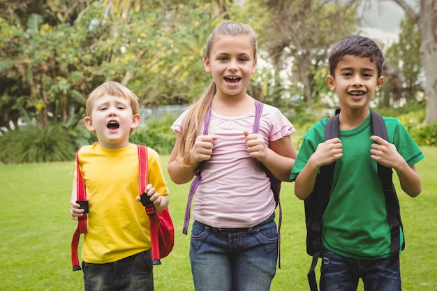 Étudiants souriants debout avec des sacs d&#39;école