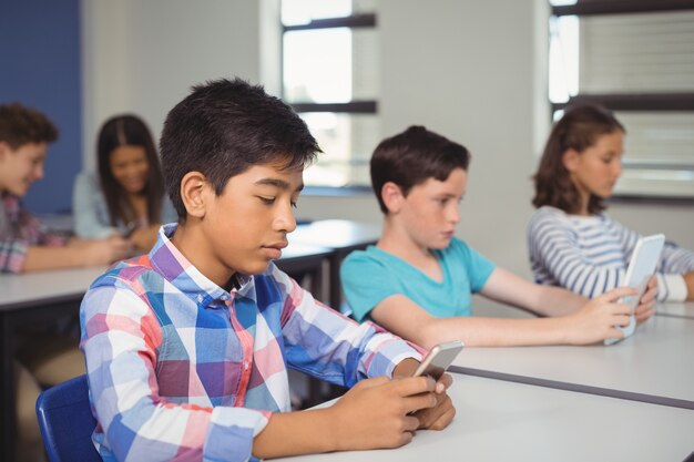 Étudiants avec tablette numérique et téléphone mobile en classe