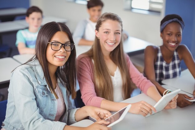 Étudiants tenant une tablette numérique en classe