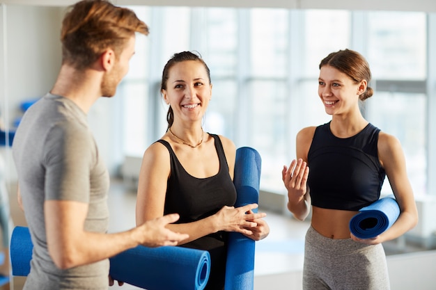 Étudiants de yoga discutant de nouveaux exercices