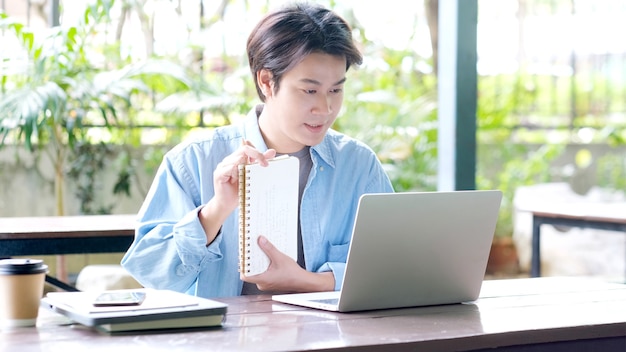 Étudier la classe en ligne, l'homme étudiant tenant une conférence tout en apprenant en ligne avec un ordinateur portable, l'éducation et la technologie