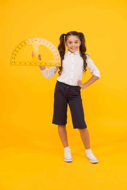 Étudier la géométrie Futur architecte Cours d'ingénierie Concept de géométrie Écolière tenant un rapporteur pour la leçon Petit enfant se préparant à la géométrie Adorable petite fille utilisant un instrument de mesure