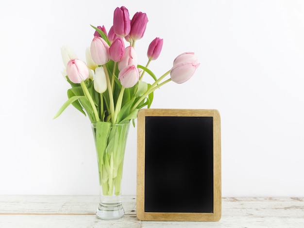 Tulipe avec cadre photo vierge sur table en bois blanc