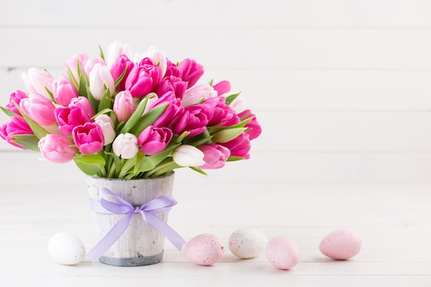 Tulipe rose sur fond blanc. Carte de voeux de Pâques et de printemps.